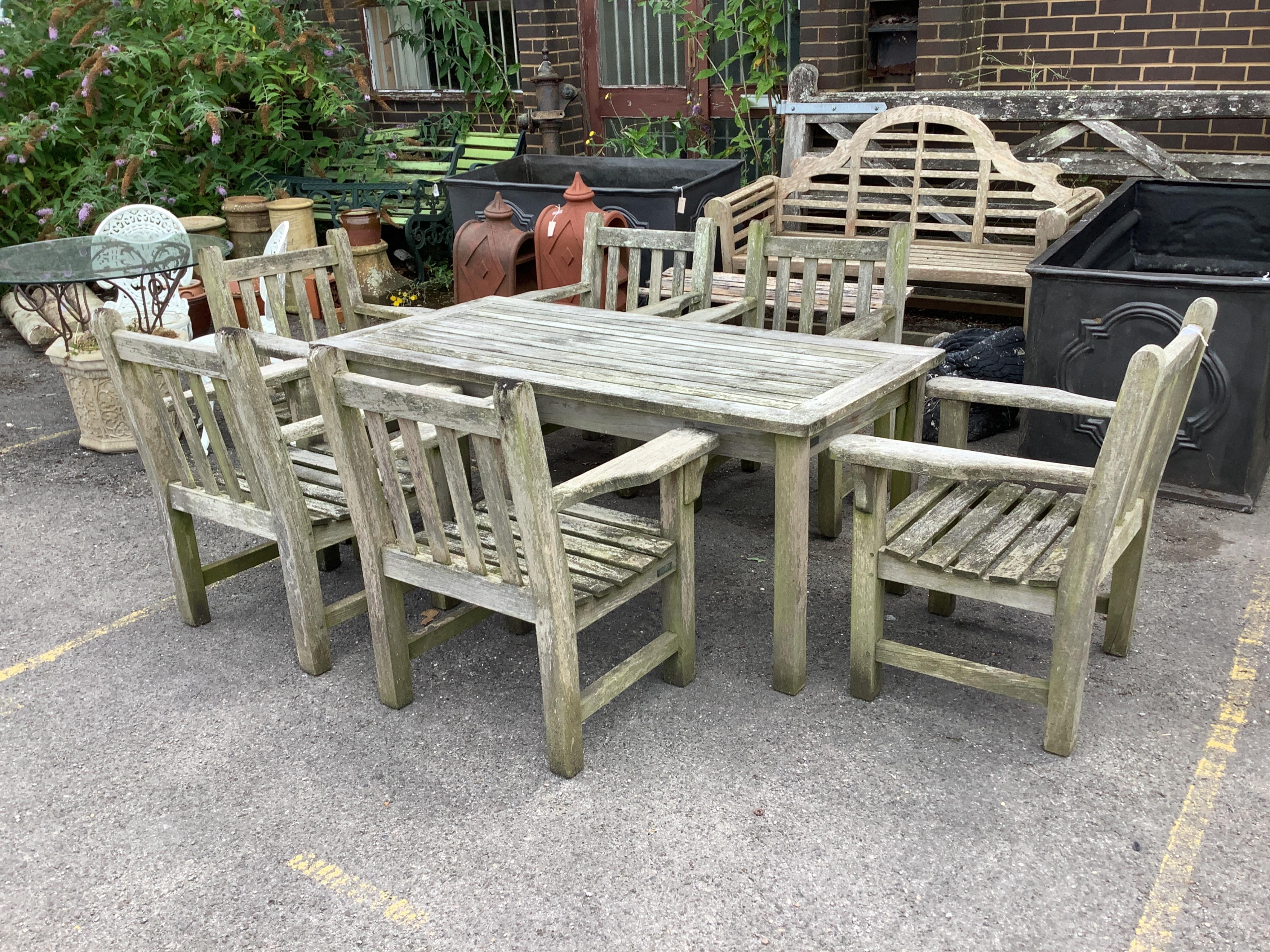 A rectangular weathered teak garden table, width 164cm, depth 79cm, height 70cm, together with a set of six weathered teak armchairs. Condition - fair